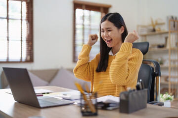 Young happy woman using laptop and celebrating victory and success, have good news, job celebrating achievement.