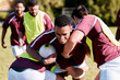 © Anela R/peopleimages.com - Team, tackle or rugby men in training, exercise or workout match on sports field running with a ball. Challenge, strong man or powerful group in tough competitive game with physical fitness or effort