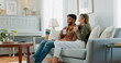 © Kirsten D/peopleimages.com - Relax, coffee and watching tv with couple on sofa together for movie, streaming service or television. Happy, love and tea with man and woman in living room at home for video, film and news lifestyle