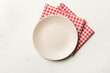 canvas print picture - Top view on colored background empty round white plate on tablecloth for food. Empty dish on napkin with space for your design