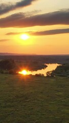 Wall Mural - Aerial view landscape of sunrise or sunset with forest and river. Vertical video