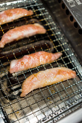 Wall Mural - Closeup and crop beef and pork slice grilling on stove. Japanese grilled meat Yakiniku.