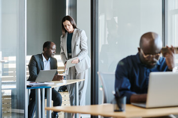 Fototapete - Young secretary with tablet making report to mature African American financial director of business company while standing by his workplace