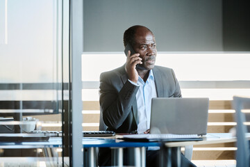 Poster - Confident mature boss in formalwear talking to subordinate or arranging appointment to applicant on mobile phonewhile sitting in office