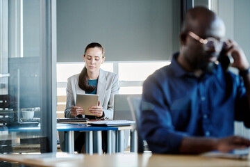 Poster - Focus on young businesswoman or secretary looking through online information describing financial development on tablet screen