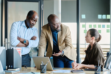 Poster - Two businessmen looking at young female colleague while one of them explaining information or points of project during presentation