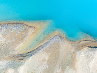 Wall Mural - clear azure water in a mountain lake. the shore with stones. view of the water from a drone. landsca