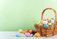 Happy Easter, Easter Painted Eggs In The Basket On Wooden Rustic Table For Your Decoration In Holiday. Copy Space.