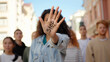 © RZ Images - Mixed race woman leader at protest showing hand with word Stop. Anti racism march demonstration