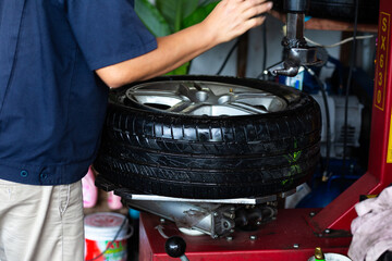 Wall Mural - Technical man working replacement car tire shop