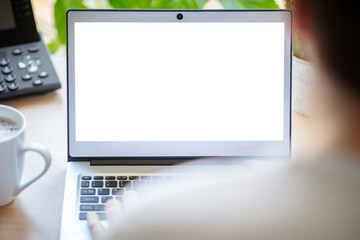 Laptop computer at office desk with blank screen background