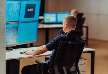 Wall Mural - Group of Security data center operators working in a CCTV monitoring room looking on multiple monitors.Officers Monitoring Multiple Screens for Suspicious Activities