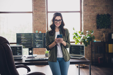 Wall Mural - photo of joyful chief web designer typing use telephone search choose website renew interface workst