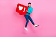 Full length photo of young handsome guy jumping hold heart like notification pinata wear trendy blue look isolated on pink color background