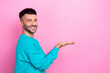 © deagreez - Profile photo of young satisfied good mood smile guy wear blue sweatshirt hold palms recommend mockup isolated on pink color background