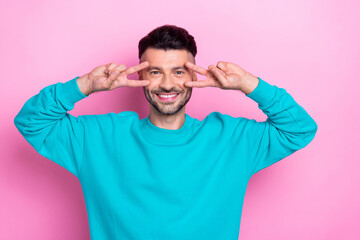 Poster - Photo of good mood positive guy student wear blue sweater showing v-sign cover fingers face peaceful candid person isolated on pink color background