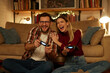 © Stockphotodirectors - Young couple having fun at home playing video games