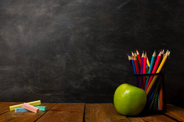 Back to school. Education background with books and apple over blackboard