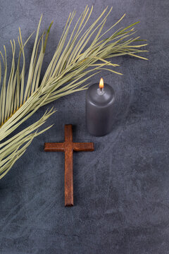 catholic cross with palm leaf and burning candle. ash wednesday, lent season, holy week, good friday