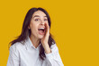© Studio Romantic - Telling great news. Joyful woman excitedly shouts something interesting to crowd, holding her hand to her mouth. Young Caucasian woman making announcement isolated on orange background. Banner.