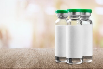 Wall Mural - Vaccine medical bottle on desk in blur hospital