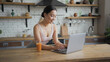 © RZ Images - Healthy asian woman using laptop and drinking orange juice