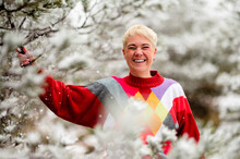 Cheerful Adult Woman Shaking Snowy Branch