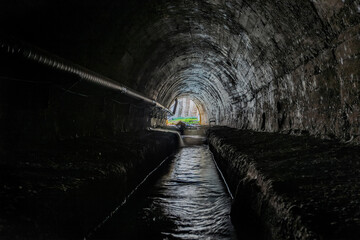 Canvas Print - Underground vaulted urban sewer tunnel with dirty sewage