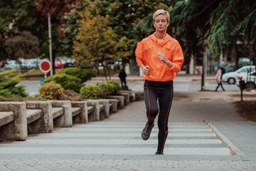 Wall Mural -  A blonde in a sports outfit is running around the city in an urban environment. The hot blonde maintains a healthy lifestyle.