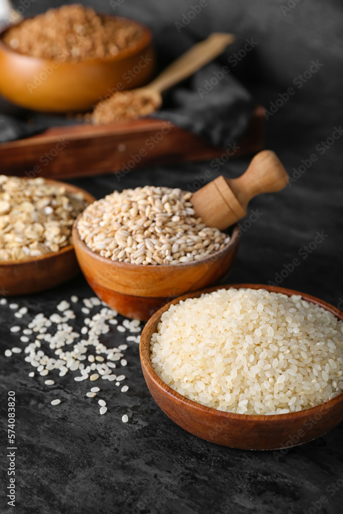 Bowls with cereals on dark background, closeup