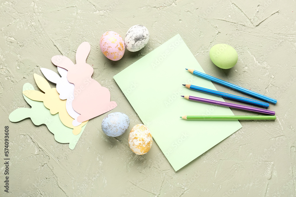 Blank card with paper rabbits, pencils and Easter eggs on grunge background