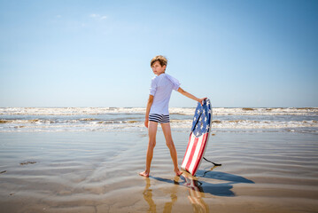 Wall Mural - Youth Child Preteen Boy Standing on the Beach with A Boogie Board 