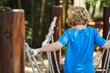 © Caseyjadew - Preschool child playing on rope swing in beautiful tropical kindergarten yard.