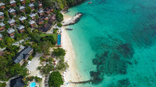 Aerial View Of Beautiful Wooden Bungalows In Tropical Rainforest Overlooking White Sand Beach And Turquoise Waters Of Andaman Sea, Phi Phi, Krabi, Thailand