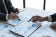 © Phimwilai - Group of Asian business people meeting new startup project pointing discussion graph and data analysis charts and graphs business finance inside office accounting concept management renew.
