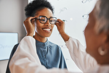 Glasses check, black woman and customer with store worker and optician looking at lense. Eye consulting, smile and eyewear assessment in a frame shop for vision test and prescription exam for eyes