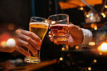 Wall Mural - food and drink male friends are happy drinking beer and clinking glasses at a bar or pub.