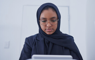 Muslim, tablet working and hijab of a serious woman employee from Dubai writing code. Islam, web data and coding program of a it worker in a office planning with business software and analytics