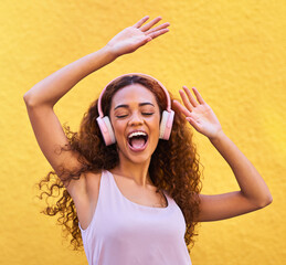 Poster - Music, freedom and dance with a black woman listening to the radio outdoor on a yellow wall background. Headphones, energy and face with an attractive young female streaming audio sound for fun