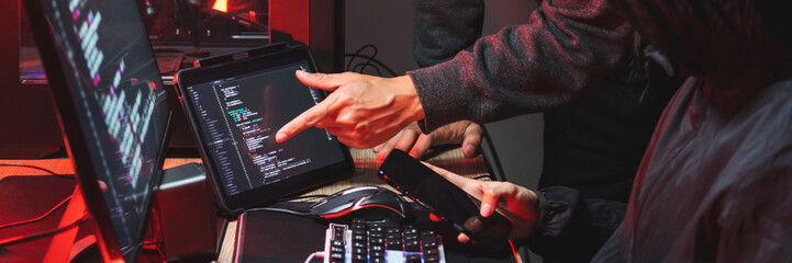 Dangerous Hooded Hacker typing bad data into computer online system and spreading to global stolen personal information. Cyber security concept