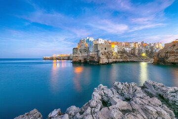 Wall Mural - Fantastic night scene at Cala Paura gulf with Bastione di Santo Stefano in village on the rocks Polignano a Mare,