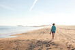 © Cavan Images - Woman walking along beach at Reid State Park