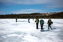 A Group Of Winter Hikers Crossing A Frozen Pond