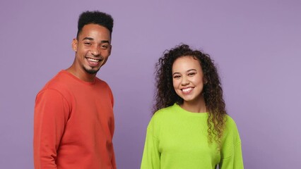 Sticker - Young couple two friends family man woman of African American ethnicity wear casual clothes together come in meet together greet giving high five clap hands folded isolated on plain purple background