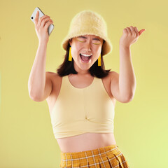 Wall Mural - Phone, wow and celebration of woman in studio isolated on a yellow background. Excited winner, surprise and happy female with mobile smartphone celebrating after winning success, good news or lottery