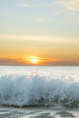 Sunset over the Indian Ocean. The calm sea water is illuminated by the rays of the setting sun. Beautiful minimalistic seascape. Blurred seascape