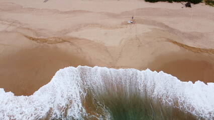 Wall Mural - Aerial view of the waves with foam on the sandy ocean shore. Beautiful texture background for tourism and design. Tropical seashore