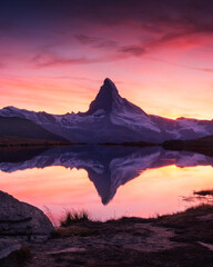 Wall Mural - Picturesque landscape with colorful sunrise on Stellisee lake. Snowy Matterhorn Cervino peak with reflection in clear water. Zermatt, Swiss Alps