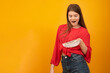 © somemeans - Surprised and happy teenage girl keeps wad of money. Earnings for young people. Yellow background. Copy space.