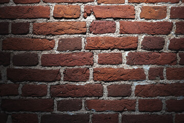 Wall Mural - Grungy dark red brick wall with spotlight, background texture